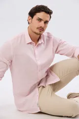 Pantalón de lino color beige, de corte recto y cintura elastizada con presillas para cinturón y bolsillos laterales.