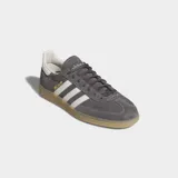 Championes Adidas Handball Spezial de ante gris con las emblemáticas tres tiras blancas en los laterales, talón blanco y suela de goma color caramelo.