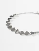 Pulsera de acero quirúrgico plateado con dijes en forma de corazón unidos por una cadena fina.