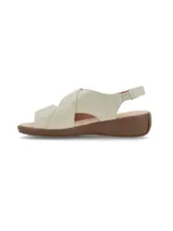 Sandalias de cuero color crema, con tira ajustable con velcro en el empeine, talón cerrado con tira elástica y suela de plataforma baja marrón.