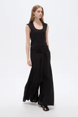 Pantalón de viscosa negro de tiro alto, diseño ancho con detalles de volados sutiles y lazo para anudar en la cintura.