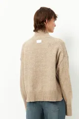 Polera de tejido de punto color bordó, con cuello alto, manga larga y costura vertical central en el frente.