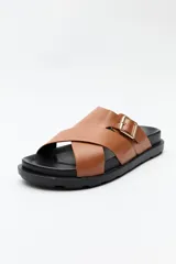 Sandalia negra con tiras cruzadas y hebilla metálica lateral.