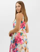 Vestido largo de chifón con estampado floral multicolor. Presenta cuello halter con plisado en el pecho, cintura drapeada y falda amplia con capas asimétricas que aportan movimiento. Incluye forro interior y cierre invisible en la espalda.