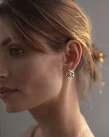 Aros de diseño minimalista en forma de corazón irregular, con acabado metálico pulido y cierre de perno con mariposa.