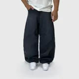 Pantalón de jean estilo ultra baggy con diseño de paneles curvos en las piernas, color negro con efecto lavado. Presenta un corte extremadamente holgado y tiro medio.