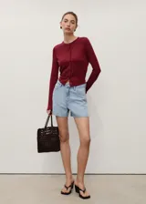 Short de jean de tiro alto con diseño recto y cinco bolsillos. Cuenta con cierre de cremallera y botón frontal, además de trabillas para cinturón.