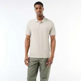 Remera polo color beige, de manga corta, con cuello y puños ribeteados en color blanco y cierre frontal de tres botones.