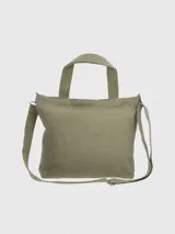 Cartera tipo tote bag de lona color verde oliva, con estampado frontal de un perro Basset Hound y el logo de la marca. Cuenta con doble asa superior, correa ajustable y extraíble, cierre principal y bolsillos internos y externos.