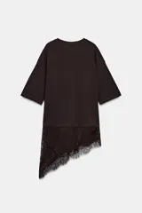 Camiseta de algodón de corte regular, color marrón oscuro o negro, con cuello redondo y manga corta. Presenta un bajo asimétrico con aplicación de encaje negro a tono.