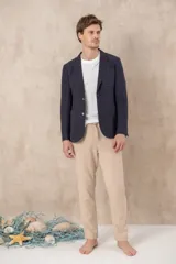 Pantalón de ramio y algodón color beige, con cintura elástica ajustable con cordón y ruedo con dobladillo.