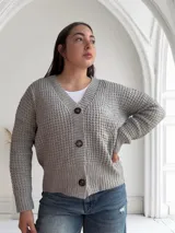 Saco de lana color gris con textura tejida y botones marrones.