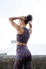 Top deportivo negro con estampado abstracto en tonos rosa, reversible.