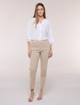 Pantalón de gabardina elastizada color beige, de tiro medio y calce slim. Cuenta con diseño pull-on sin cierres ni botones, cintura ancha, bolsillos delanteros simulados y bolsillos traseros ojal.