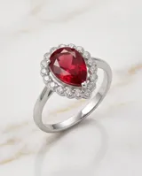 Anillo de plata con piedra central roja en corte gota, rodeada por circonias cúbicas.