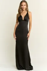 Vestido largo de corte sirena con escote profundo en V y espalda descubierta. Confeccionado en tela fluida con acabado satinado, presenta un diseño entallado que se ajusta al cuerpo.