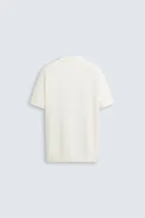 Polo de punto canalé color rosado, de corte regular fit, con cuello solapa y cierre frontal de botonadura. Manga corta y acabados en rib.