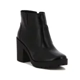 Botín de cuero sintético negro, con caña baja, punta redondeada, cierre lateral y taco cuadrado.