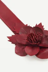 Cinturón ancho de cuero color marrón con hebilla metálica y aplique de flor de cuero artesanal.