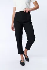 Pantalón de vestir negro, corte carrot con botón y cierre frontal.