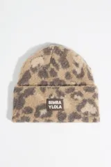 Gorro tipo beanie de punto con estampado animal print de leopardo en tonos beige y gris. Presenta un parche rectangular con el logo de la marca en la parte frontal.