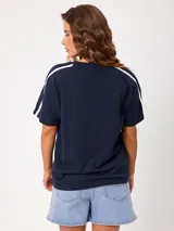 Remera blanca con estampado frontal de la marca Rusty y tiras laterales en las mangas, de ajuste holgado y 100% algodón.