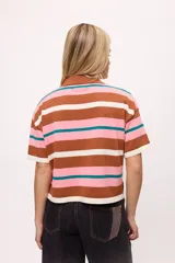 Remera tejida de algodón con cuello polo amarillo, corte boxy y estampado de rayas horizontales en tonos azul claro, marrón, rojo y amarillo.