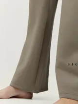 Pantalón largo color marrón de tejido técnico con tecnología performance, cintura ajustable, bolsillos laterales y corte recto holgado.