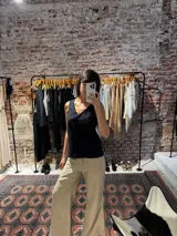 Musculosa negra con escote en V y delicados detalles de bordado broderie en la parte superior.