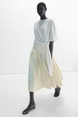Falda midi de tiro medio ZARA Woman Collection confeccionada en hilatura con lino, con detalle de pliegues, bajo acabado en línea evasé y cierre lateral con cremallera oculta en costura.