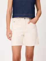 Short de denim elastizado de tiro alto, color beige, con bolsillos delanteros y traseros, y cierre frontal con botón y cremallera.