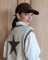 Gorra tipo visera confeccionada en cuero con textura de pelo, diseño clásico con ojales metálicos de ventilación y ajuste posterior.