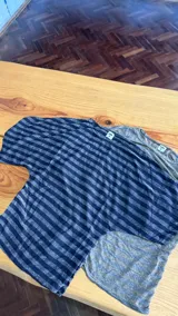Remera de manga corta ajustada en la cintura, confeccionada en jersey rayado con brillo en tonos azul y plateado, con diseño de rayas horizontales y mangas amplias.