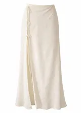 Falda larga de corte fluido confeccionada en encaje con diseño floral sutil. Presenta un cierre lateral con lazos ajustables y una abertura frontal que aporta movimiento a la prenda.