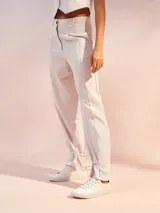 Pantalón de tiro alto color negro, confeccionado en mezcla de lino. Presenta corte recto con pinzas en la cintura, bolsillos laterales y un detalle de ajuste con lazo en los tobillos que crea un efecto acampanado.