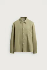 Camisa de corte regular fit en color verde militar, confeccionada en mezcla de lyocell, algodón y lino. Presenta cuello camisero, manga larga con puños abotonados, cierre frontal de botones y un bolsillo aplicado en el pecho.