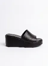 Sandalia de plataforma Aura modelo Verbena, color negro, confeccionada en 100% cuero vacuno. Diseño minimalista con capellada ancha y plataforma enteriza forrada en el mismo material.