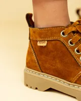 Bota acordonada de cuero color óxido con suela track color beige.