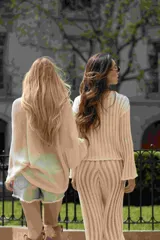 Pantalón palazzo color beige, tejido en punto calado, con cintura alta ajustable con lazos.