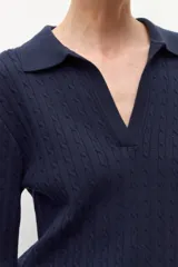 Sweater azul marino de tejido de punto con cuello polo y escote en V. Presenta un diseño de trenzas verticales en toda la prenda y mangas largas.