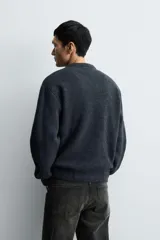 Jersey de punto con textura efecto pelo, corte boxy fit, cuello redondo y manga larga con acabados en rib.