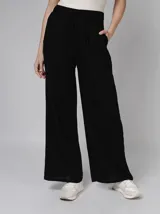 Pantalón negro de lino con corte palazzo, cintura elástica con cordón ajustable y bolsillos laterales.