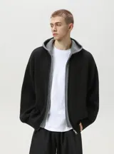 Campera de punto grueso acanalado en color negro con interior y capucha gris, diseño de doble capa y cierre frontal con cremallera.