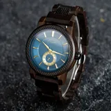 Reloj Chenaut Saphir d’Ébène con movimiento de cuarzo, caja y malla de madera de ébano, esfera azul zafiro con detalles dorados, cristal Hardlex resistente a los arañazos y cierre oculto con botón.