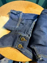 Bombacha de campo Sierra Mora confeccionada en denim de algodón, de tiro medio, con bolsillos y bordado de un caballo en el bolsillo trasero. Cuenta con pretina con botones, cierre delantero y puños ajustables con botones.