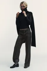 Pantalón de tiro alto con diseño de cuadros, corte recto y cintura con trabillas. Cuenta con bolsillos laterales, falsos bolsillos traseros de vivo y cierre frontal con cremallera, botón y ganchos metálicos.