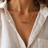 Collar de cadena eslabonada en goldfilled dorado con dije central con la palabra "Mom" incrustada de circonias multicolores.