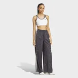 Pantalón Adidas Originals wide leg de satén, con estampado animal print en tonos grises y negros, cintura elástica y las clásicas tres tiras blancas a lo largo de los laterales.