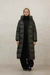 Chaqueta larga acolchada color verde militar, con capucha y cierre frontal. Confeccionada con poliéster 100% reciclado, forro y relleno PrimaLoft 100% reciclados.