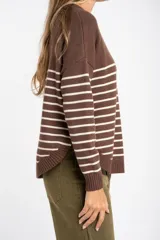 Sweater marrón con rayas horizontales blancas, de corte holgado y manga larga. Tejido suave y liviano de viscosa, poliéster y poliamida.